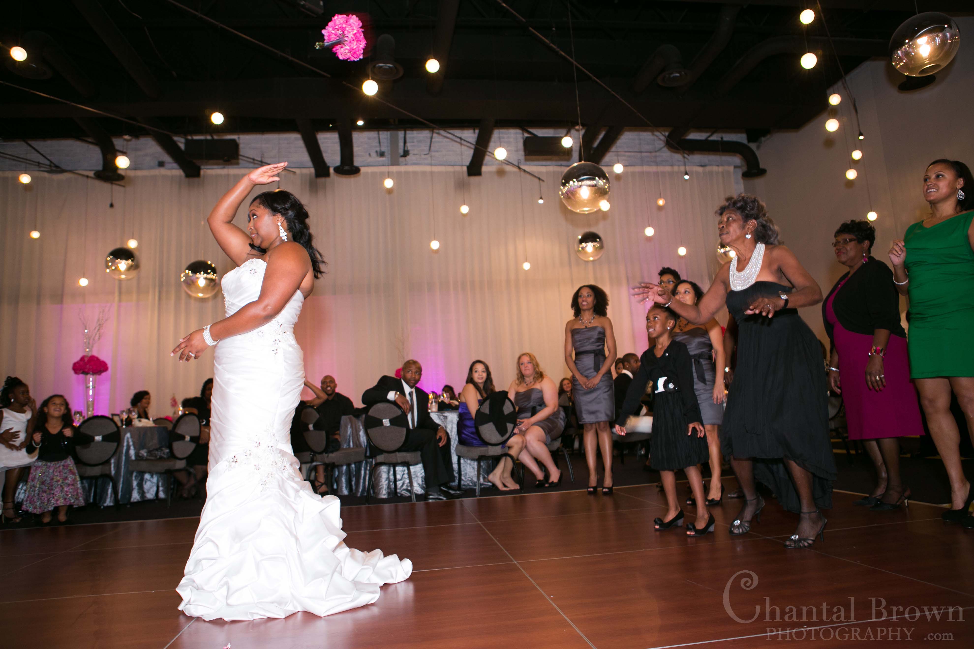 bride toss pink flowers bouquet at NYLO Hotel wedding reception in Dallas Wedding Photographer